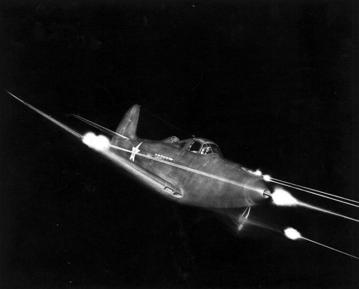 Bell P-39 Airacobra firing all weapons at night.