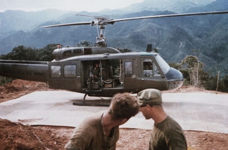 A U.S. Army Bell UH-1D Iroquois helicopter rests on a recently installed landing mat at a mountain-top fire support base. The base was under construction by members of the U.S. 3rd Marine Division, 1968