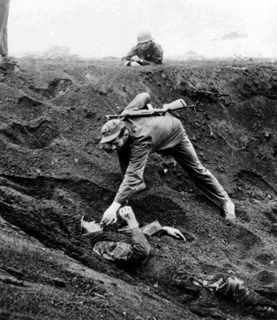 This Japanese soldier played dead for almost two days half buried in a shell hole holding a live grenade. Promising no resistance, he was given a cigarette before being removed from the hole, Iwo Jima, 16 March 1945.
