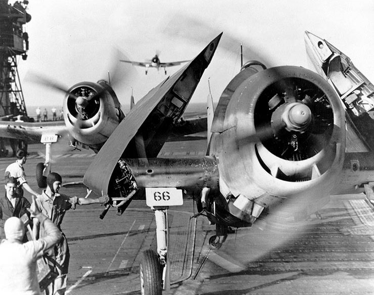 Grumman F6F-3 “Hellcat” fighters landing on USS Enterprise (CV-6) after strikes on the Japanese base at Truk, 17-18 February 1944. Flight deck crewmen are folding planes’ wings and guiding them forward to the parking area.