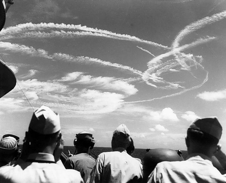 Fighter plane contrails mark the sky over Task Force 58, during the “Great Marianas Turkey Shoot” phase of the battle, 19 June 1944. Photographed from on board USS Birmingham (CL-62)