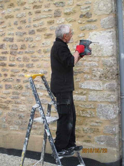 Francis Julien begins drilling the anchor holes for the new plaque.