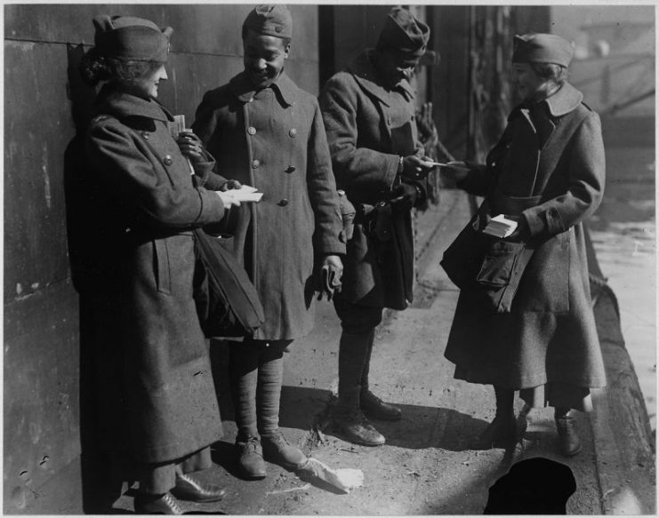 Salvation Army girls giving sweets to returned American soldiers.