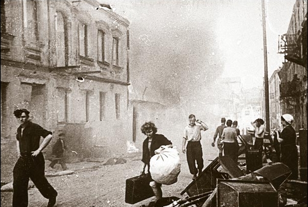 Minsk civilians carry belongings out of burning houses, early July 1944.