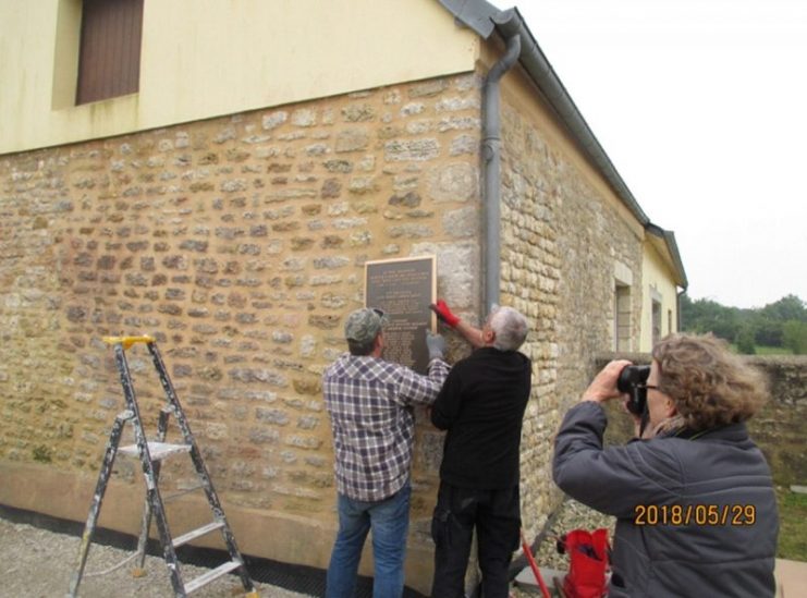 Nancy White captures the moment as Francis and Eric mount the new plaque into the perfectly measured mounting holes.