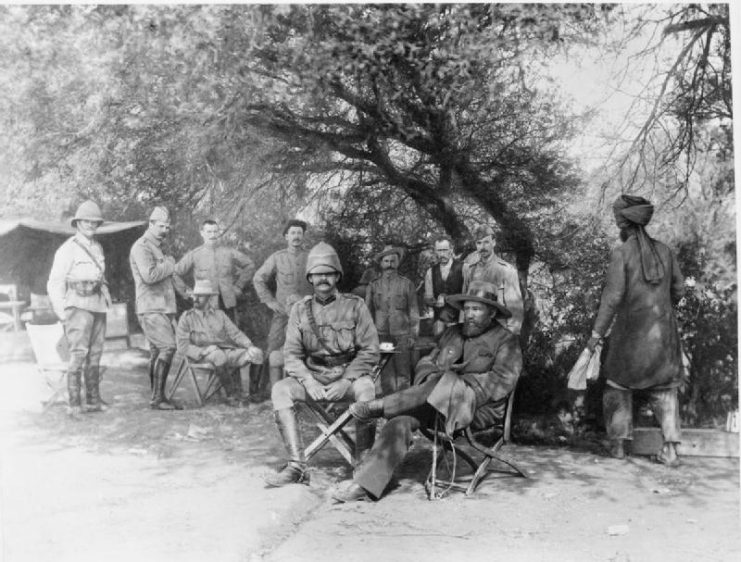General Piet Cronje (in broad-brimmed hat) seated in the shade with British officers after his surrender at the Battle of Paardeberg.