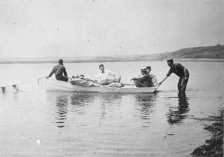 The injured helsman John Bogovich is transported from the beach. (Orleans Historical Society)