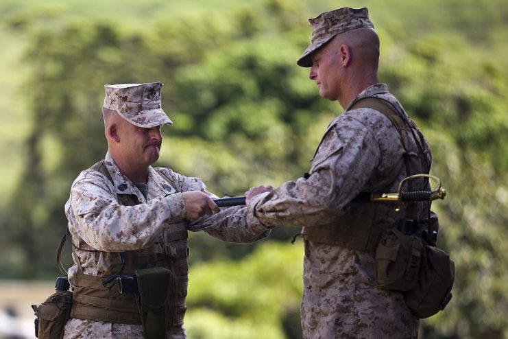 Sgt. Maj. Justin LeHew, outgoing regimental sergeant major, left, hands over the Noncommissioned Officers’ Sword to Col. Timothy Winand, commanding officer of 3rd Marine Regiment, during a relief and appointment ceremony at Dewey Square aboard Marine Corps Base Hawaii, 20 August 2013. Sgt. Maj. Vincent Santiago, incoming regimental sergeant major, relieved LeHew of his duties. (U.S. Marine Corps photo by Lance Cpl. Matthew Bragg/RELEASED)