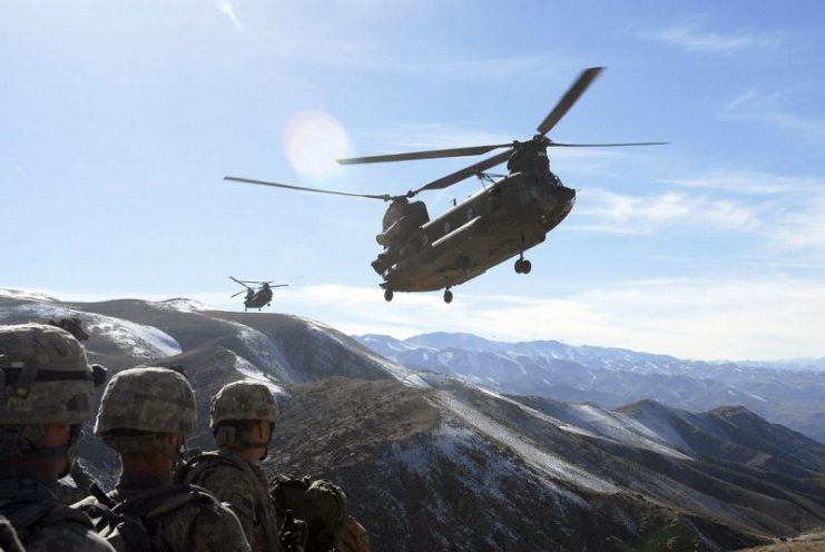 Standing by on a hilltop, Soldiers with the 101st Division Special Troops Battalion, 101st Airborne Division watch as two Chinook helicopters fly in to take them back to Bagram Airfield, Afghanistan, Nov. 4, 2008. The Soldiers searched a small village in the valley below for IED making materials and facilities.