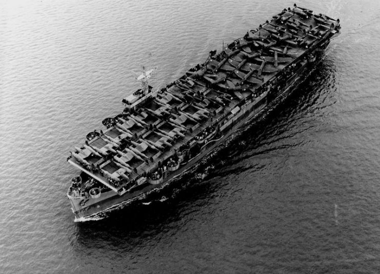 The U.S. Navy escort carrier USS Barnes (ACV-20) underway in the Pacific Ocean on 1 July 1943, transporting U.S. Army Air Forces Lockheed P-38 Lightning and Republic P-47 Thunderbolt aircraft.