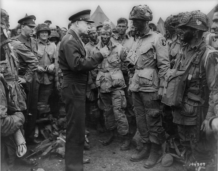 General Dwight D. Eisenhower speaking with 1st Lieutenant Wallace C. Strobel and men of Company E, 502nd Parachute Infantry Regiment on 5 June. The placard around Strobel’s neck indicates he is the jumpmaster for chalk No. 23 of the 438th TCG.