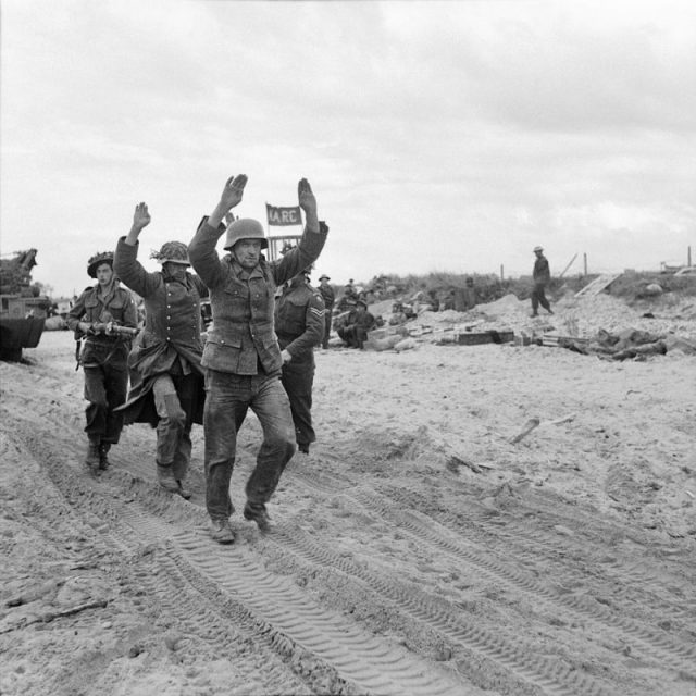 German POWs being escorted along one of the Gold area beaches, 6 June 1944.