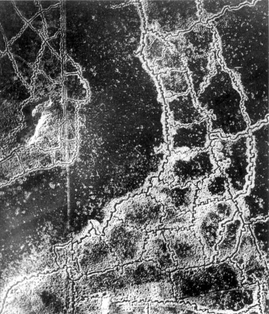 An aerial reconnaissance photograph of the opposing trenches and no-man’s land between Loos and Hulluch in Artois, France, taken at 7.15 pm, 22 July 1917. German trenches are at the right and bottom, British trenches are at the top left. The vertical line to the left of center indicates the course of a pre-war road or track.