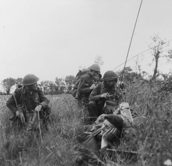 A Commando officer of 1st Special Service Brigade (left) with 3rd Division signallers using man-pack radio sets during the move inland, 6 June 1944.