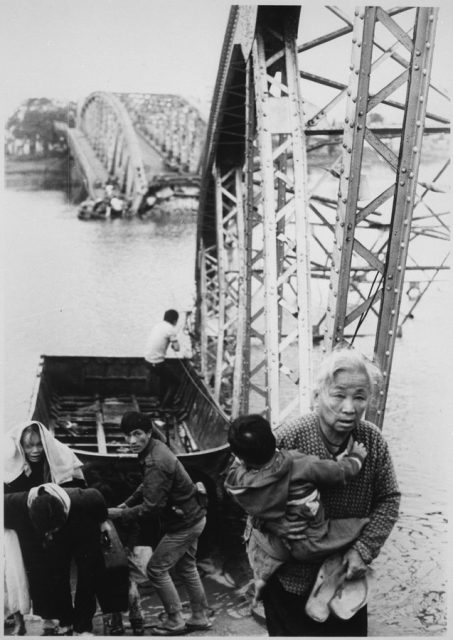Vietnamese civilians escaping the fighting pass the destroyed Trường Tiền Bridge