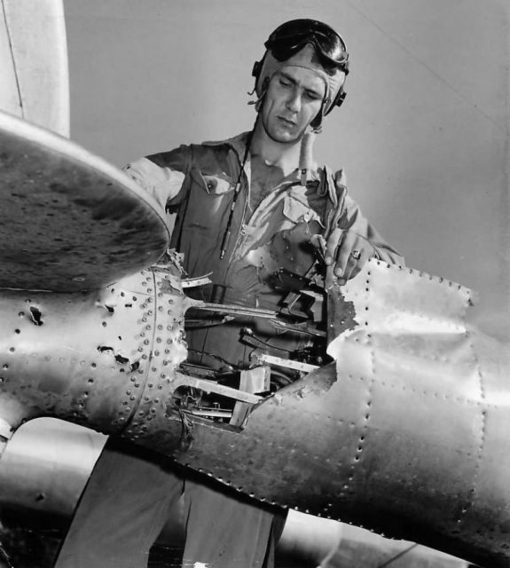Lt Robert Amon inspecting damage to the tail boom of his P-38.