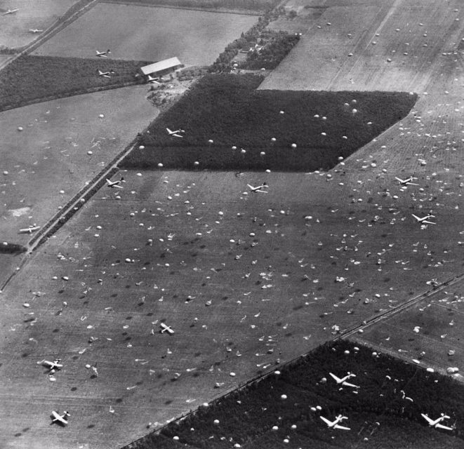 Oblique photographic-reconnaissance aerial showing Douglas Dakotas dropping paratroops of 1st Airborne Brigade on to Dropping Zone (DZ) ‘X’, at Renkum, west of Arnhem. 17 September 1944