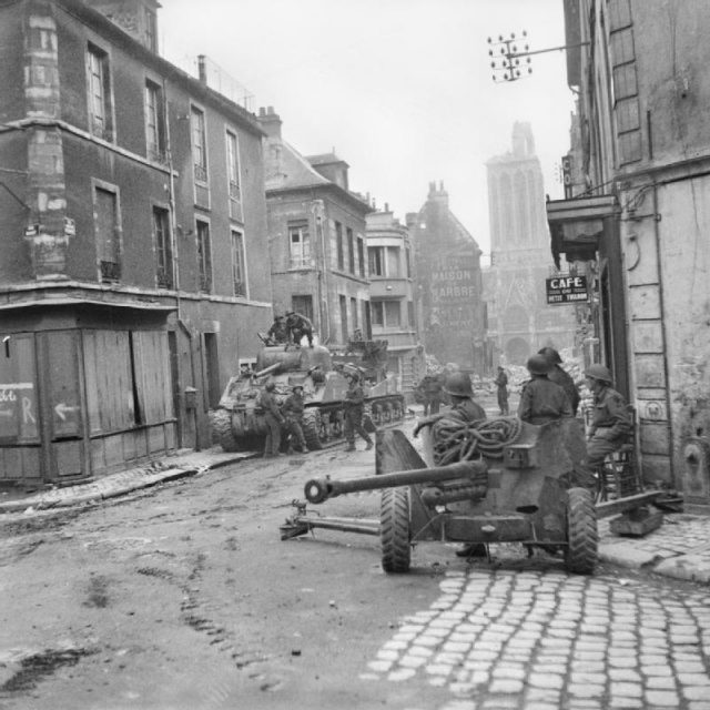 Sherman tanks and 6-pdr anti-tank gun in the centre of Caen, 10 July 1944.