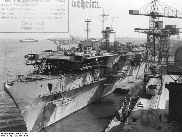 The Graf Zeppelin at Kiel, June 1940, displaying her newly rebuilt bow. Also visible are her 15 cm casemate guns, before their removal to defend occupied Norway. The photo is marked Geheim (“secret”). Photo: Bundesarchiv, RM 25 Bild-62 / CC-BY-SA 3.0