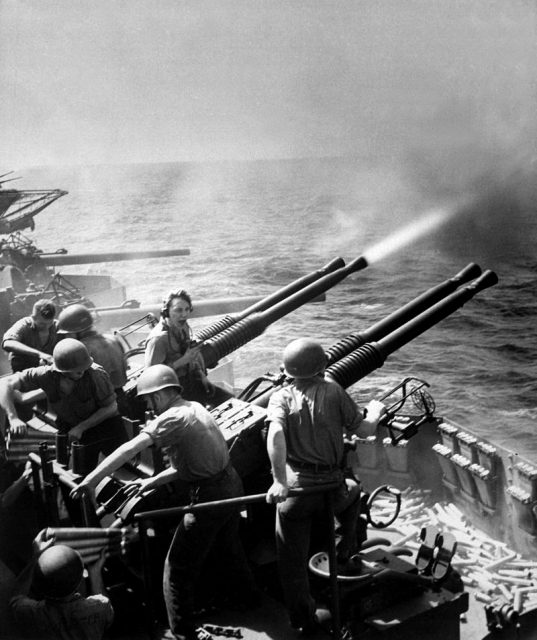 40mm guns firing aboard the U.S. aircraft carrier USS Hornet (CV-12) on 16 February 1945, as the planes of Task Force 58 were raiding Tokyo. Note expended shells and ready-service ammunition at right.