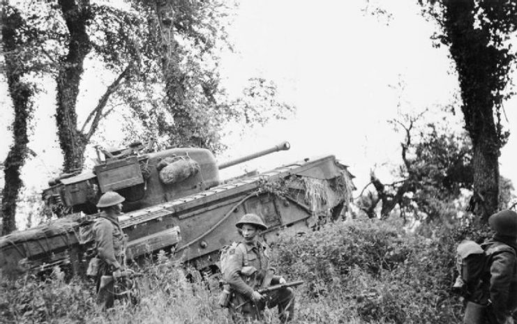 A Churchill tank of 7th Royal Tank Regiment, 31st Tank Brigade, supporting infantry of 8th Royal Scots during Operation Epsom, 28 June 1944.