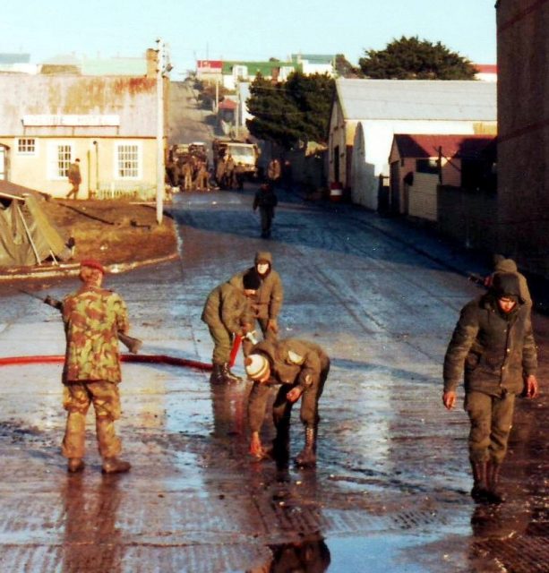 Conscripts cleaning the streets of Port Stanley after Argentine forces surrender 14 June 1982. PhotoL: Ken Griffiths CC BY-SA 4.0
