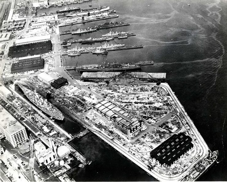 In the right foreground is the aircraft carrier USS Bunker Hill (CV-17) and a Baltimore-class heavy cruiser, either USS Baltimore (CA-68) or USS Boston (CA-69).