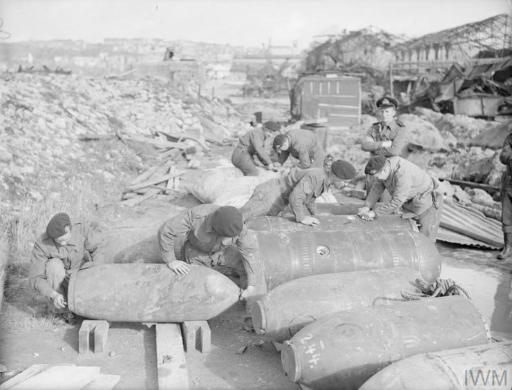 Royal Marines of the Bomb Disposal and Render Mines Safe Squad dealing with German G mines and parachute mines recovered from under dock walls in Boulogne. © IWM.