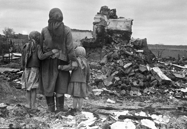 Local family in front of their ruined house. Photo: RIA Novosti archive, image #982 S. Alperin CC-BY-SA 3.0