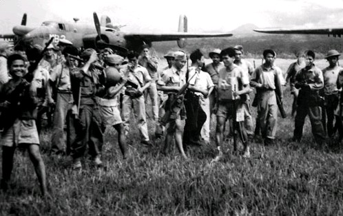 Philippine guerillas greet the crews of U.S. Marine Corps North American PBJ-1D Mitchell Bombers on Mindanao, 1945.