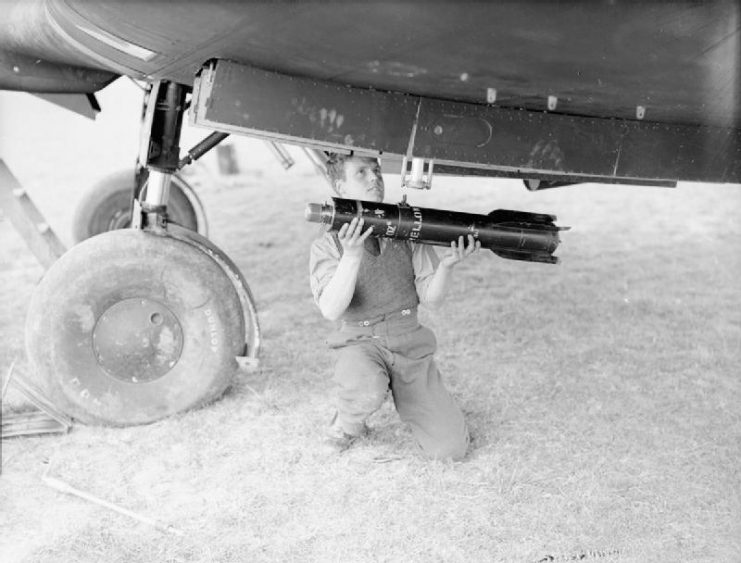Royal Air Force- France, 1939-1940. An armorer loads a 4.5 inch reconnaissance flare into the wing cell of a Fairey Battle