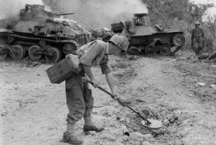 Type 95 “Ha-Go” tanks in the background while California National Guardsman sweeps for mines, Leyte 1944