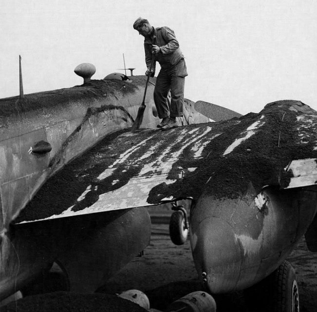 Crew member sweeping ashes off a B-25 of the 340th Bomb Group at Pompeii Field, Italy. Ash came from an eruption of Mt Vesuvius on 23 March 1944 that rained hot ash and brimstone on the area damaging several aircraft. Note the front wheel in the air.