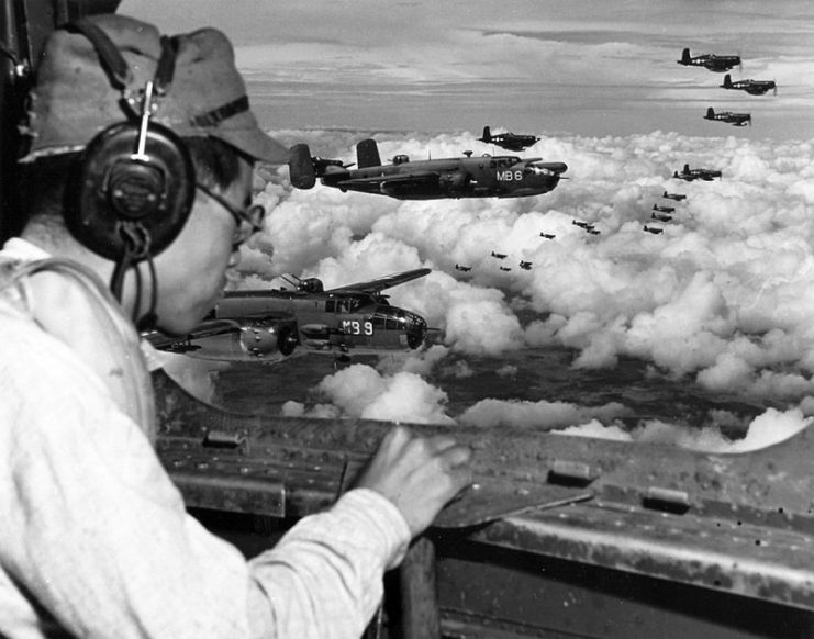 From the radio operator’s position in a USMC PBJ Mitchell, Japanese POW 2Lt Minoru Wada looks for landmarks to find the Japanese 100th Infantry Division headquarters complex, 9 August 1945, Mindanao, Philippines.