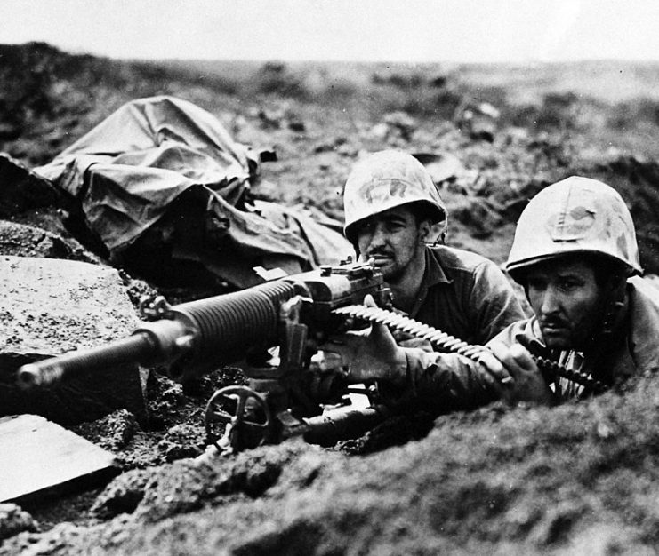After their own gun was knocked out on Iwo Jima, Marines of the Fifth Division took over this captured Hotchkiss machine gun and gave the enemy back some of its down lead.