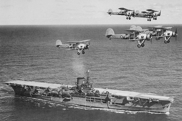 The Royal Navy’s HMS Ark Royal in 1939, with Swordfish biplane fighters passing overhead. The British aircraft carrier was involved in the crippling of the German battleship Bismarck in May 1941