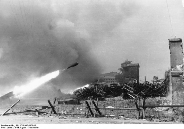 A 28/32 cm rocket in flight during the Warsaw Uprising, with piles of spent cases on the right. By Bundesarchiv Bild CC-BY-SA 3.0