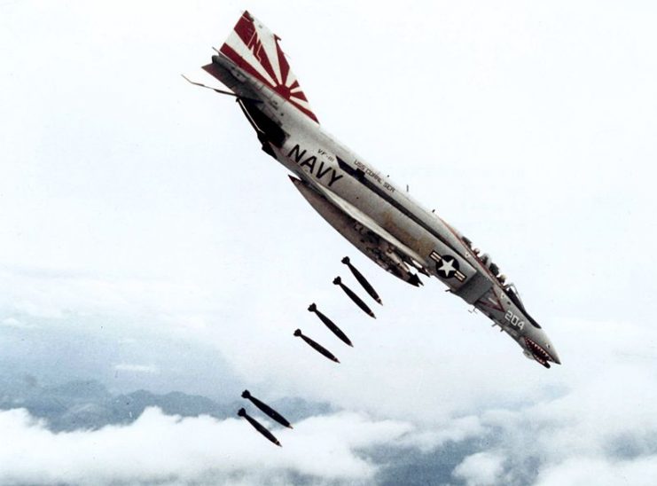 McDonnell F-4B Phantom II of Fighter Squadron VF-111 Sundowners drops 227 kg Mk 82 bombs over Vietnam during 1971. VF-111 was assigned to Attack Carrier Air Wing 15 aboard the aircraft carrier USS Coral Sea for a deployment to Vietnam from 12 Nov 1971 to 17 July 1972.