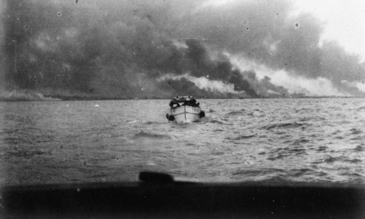 The British Army in Malaya 1942. A launch returning from an island in Keppel Harbour at Singapore after Royal Engineers had set fire to oil storage tanks there, January 1942.