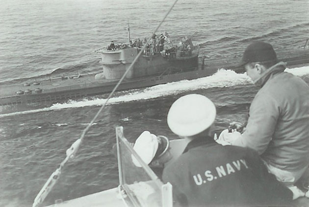 U-234 surrendering. Crewmen of Sutton (DE-771) in foreground with Kptlt. Johann-Heinrich Fehler (left-hand white cap)