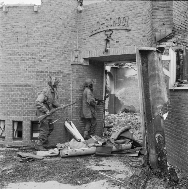A Dutch school damaged by mortar fire, being searched for German snipers by Sergeant J. Whawell and Sergeant J. Turrell of the Glider Pilot Regiment.