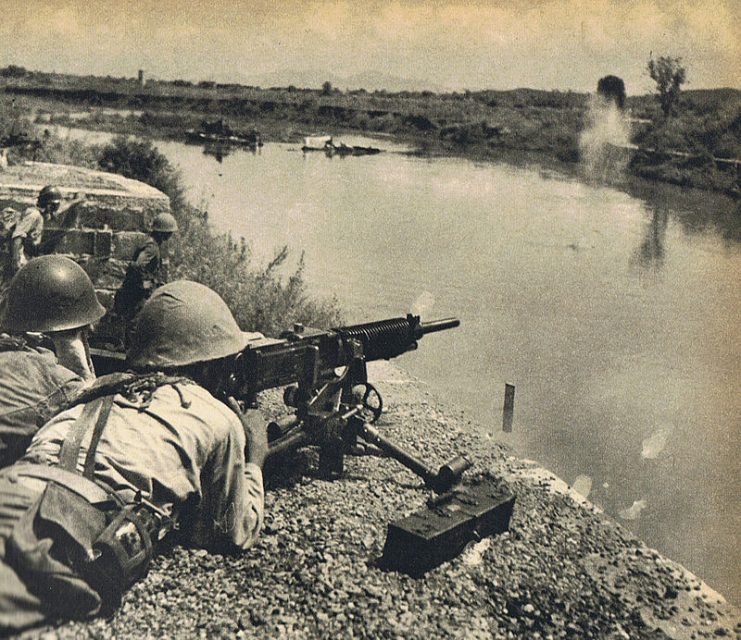 A soldier of the IJA 4th Division firing a type 92 heavy machine gun at Miluo river, Húnán Province, China.