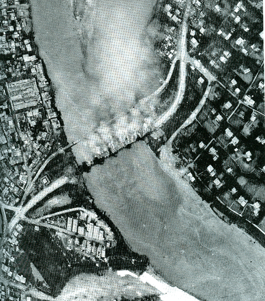 Dong Ha Bridge burning four days after destruction, 6 April 1972. At the far right are enemy armored vehicles exposed to air attacks and unable to advance.