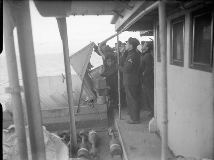 Hedgehog, a 24 spigot anti-submarine mortar. Greek naval ratings being instructed at the control panel of the Hedgehog on board the Greek corvette HHMS TOMPAZIS
