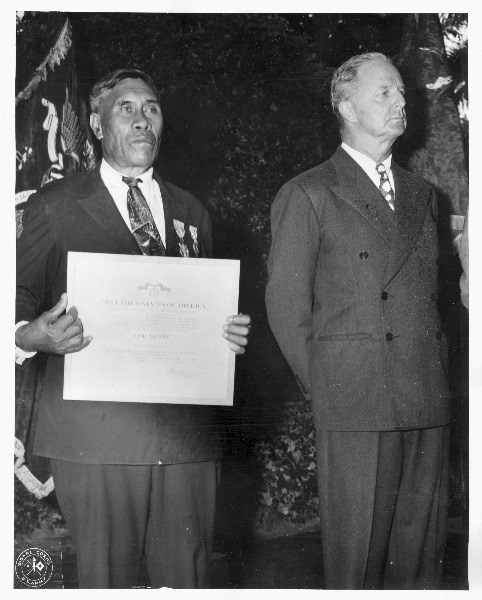 Benehakaka Kanahele holding Medal of Merit and Purple Heart presentation