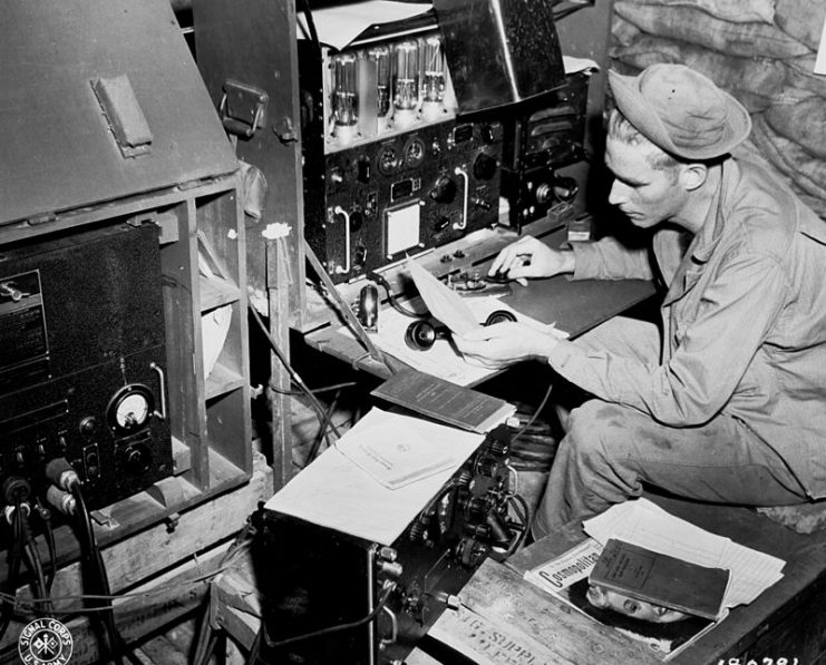 Radio Operator operating his SCR 188 radio.He is transmitting by radiotelegraphy tapping on a telegraph key which turns the transmitter on and off, transmitting pulses of radio waves which spell out a text message in Morse code.