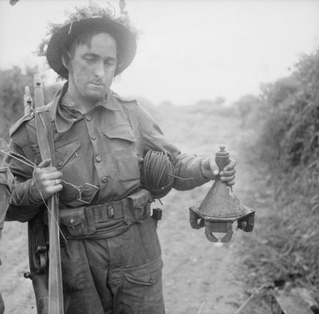 Lance Corporal Lodge of 278 Field Company, Royal Engineers, holding a German hollow charge anti-tank magnetic mine during Operation ‘Epsom’, 26 June 1944.