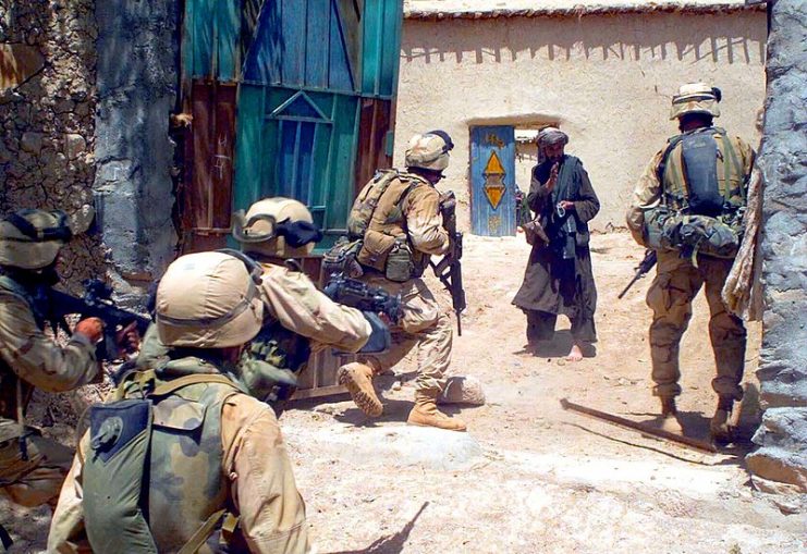 U.S. Marines from Alpha Co., Battalion Landing Team 1st Bn., 6th Marines, startle the owner of a compound who refused to open his door for a search during Operation EL DORADO.(Operation Enduring Freedom)