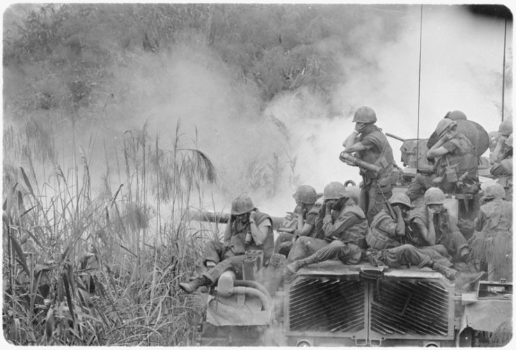 US Marines riding atop an M48 tank while firing