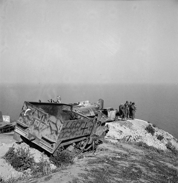 US troops with abandoned German equipment including an M3 halftrack.